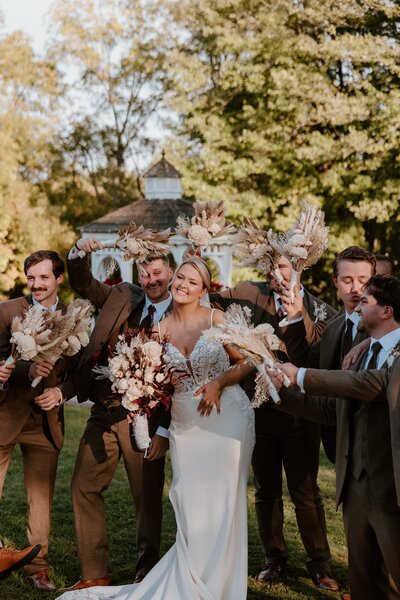 Bride sharing a fun moment with groomsmen during wedding.