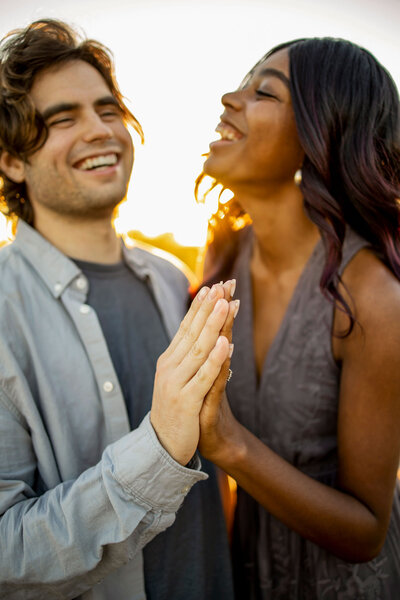 A couple laughs in the sun at the engagment phot session at Grapevine Lake