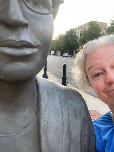Joanne smiling next to a statue