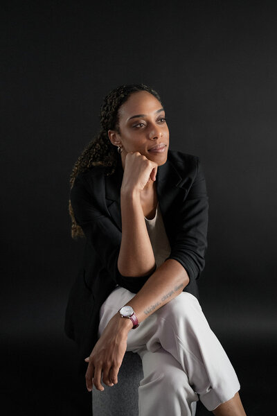woman sits with hand on chin studio headshot Tampa