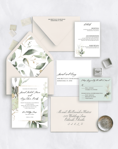Flat lay of a botanical-themed wedding invitation suite 