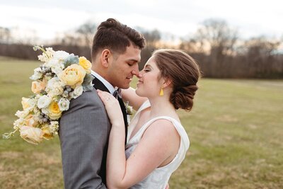 Soft yellow and white bouquet  nose to nose in a field