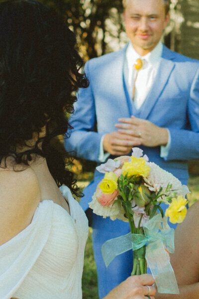 bride looks back at groom as he smiles at her