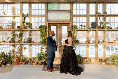 Couple saying their vows in a greenhouse.