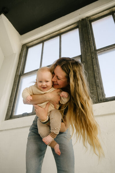 mom holding baby smiling
