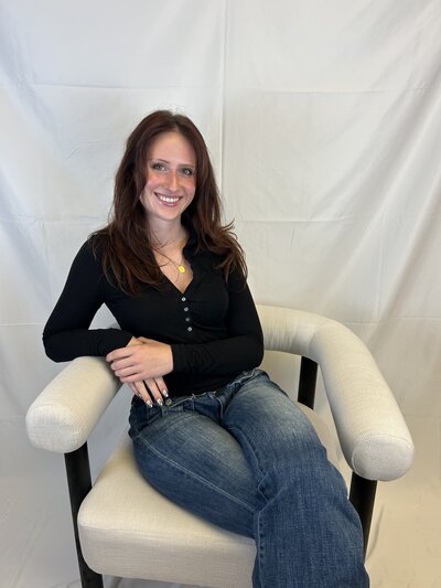 Katie, beauty provider at Lavender & Ink Studios, smiling in salon chair