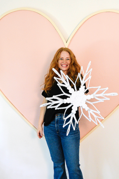 A Christmas designer holding a giant snowflake