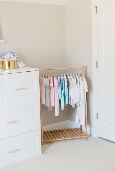Children’s clothing hanging neatly on a rack in a bright room.