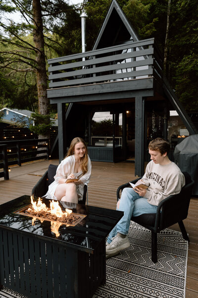 Couple writing vows together at their rental cabin.