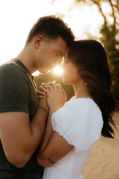 man holding woman up kissing her