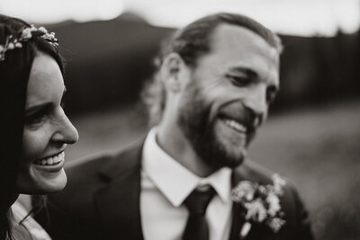 Smiling couple in wedding attire sharing a quiet, joyful moment during their Breckenridge elopement.