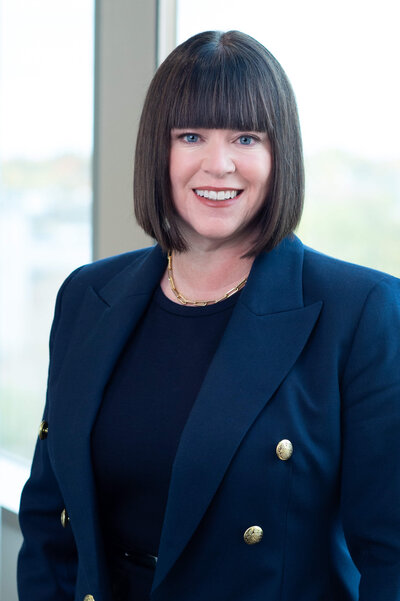 a classic corporate headshot showing a woman in a blue suit with gold buttons.  Captured by Ottawa Event Photographer JEMMAN Photography COMMERCIAL