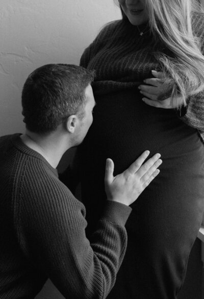 Dad kissing the moms belly during maternity photos in Green Bay Wisconsin. 