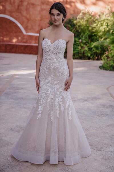 We adore the gorgeous contrast between a demure high neckline and long sleeves paired with a jaw-dropping open back.