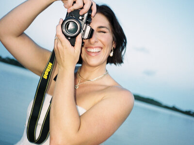 Film photo of Courtney Leigh holding up a film camera to her face