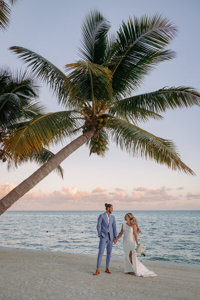 man and woman walking down the beach