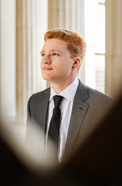 High-school senior dressed in a suit and tie, looking off into the distance