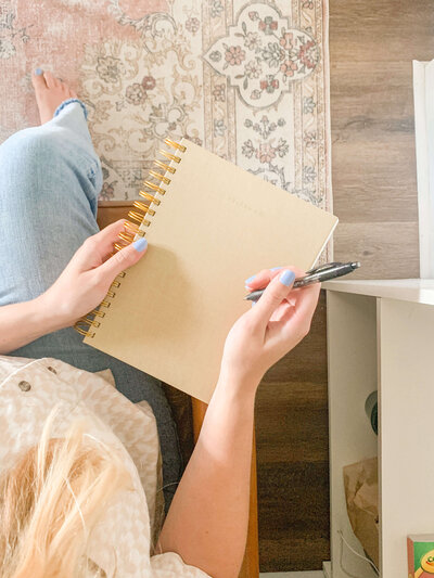 Image of woman holding a notebook in her lap