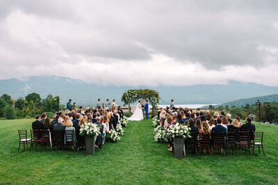 New England couple getting married outdoors surrounded by guests