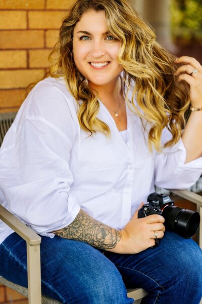 Woman in smiling at camera holding camera