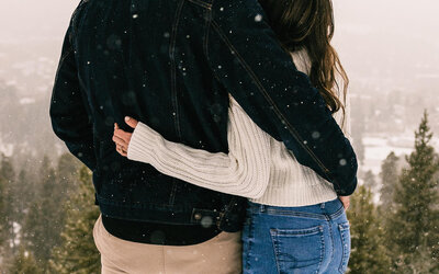 Couple snuggled up with snow falling in Breckenridge, Colorado