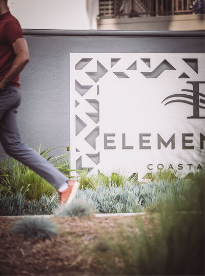 Exterior sign for Elements 616 Coastal apartments surrounded by modern landscaping and clean architectural details.