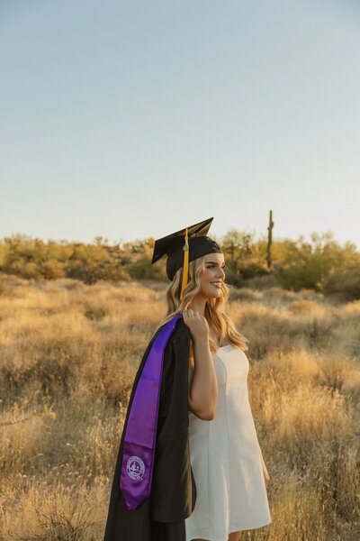 girl poses in arizona desert for graduation photos