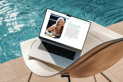 A laptop rests on a chair beside a sparkling pool, showcasing a vibrant design for a nutritionist website by Unica Formo.