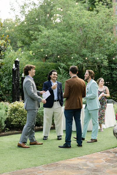 Stylish wedding guests enjoy signature cocktails and conversation during an elevated outdoor cocktail hour at a luxury Austin wedding at The Hummingbird House.