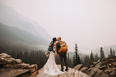 photo of couple kissingin front of helicopter that was part of their Banff elopement package