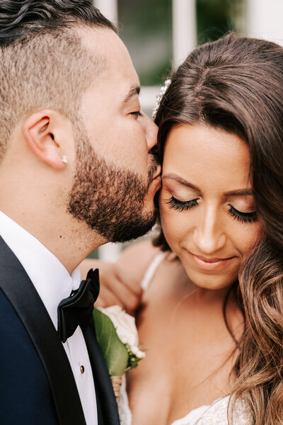 Groom giving his bride a kiss at their Ryland Inn wedding in Whitehouse Station New Jersey