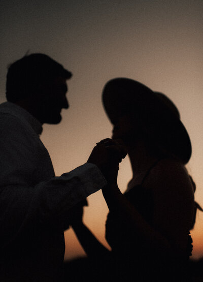 Kansas sunset engagement session  as couple holds hands and looks at eachother