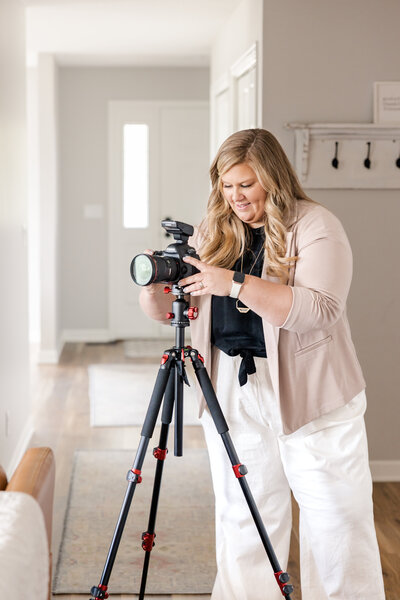 A dynamic behind-the-scenes shot of Meg Williamson capturing the beauty of a custom home. This image showcases her expertise and passion for architectural photography, highlighting her hands-on approach during a custom home shoot.