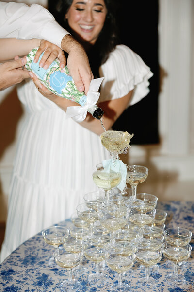 bride is pouring champagne into their champagne tower during their colorado wedding day.