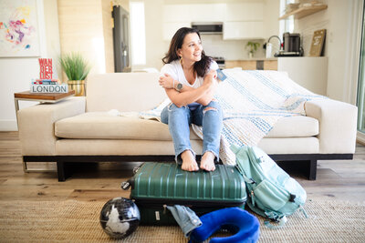 photo of the brand photographer posing with her luggage to showcase her passion for traveling 