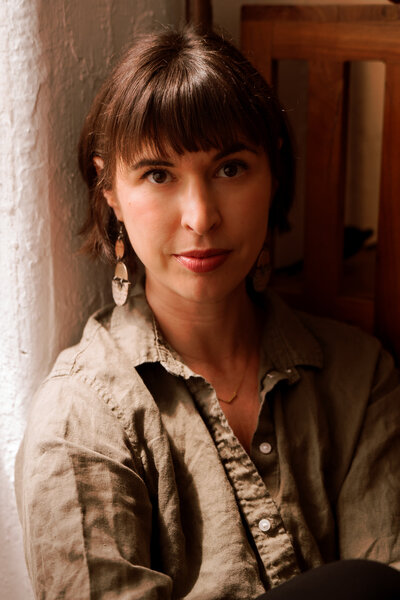 Sybil Ottenstein, somatic therapist and clinical director, seated in a cozy Brooklyn therapy office, offering body-based psychotherapy in NYC.