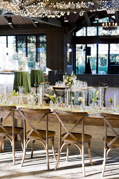 wooden chairs and table with tulips in glass bud vases sitting on the table