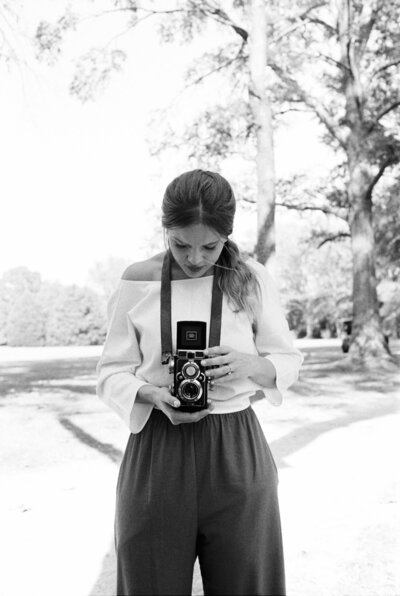 Black and white lifestyle image of a woman shooting film