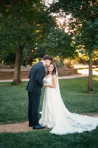 bride and groom embracing while gently smiling