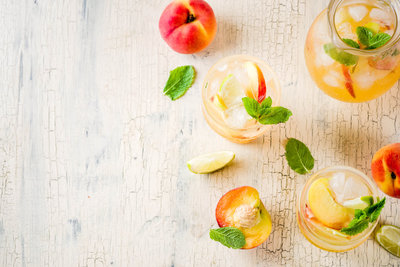 Specialty cocktails garnished with peach & mint