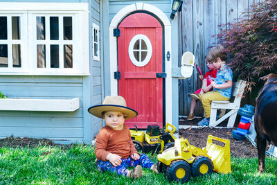 Kids playing in a playhouse in a backyard