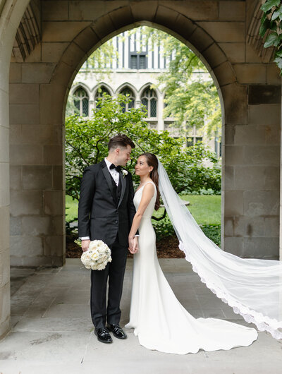 Close up of a brides hand and ring holding her bouquet with the veil