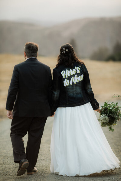 Bride and groom walking with custom wedding jacket