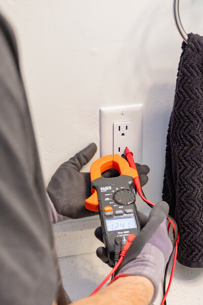 Dove Electric electrician testing outlet in bathroom in home