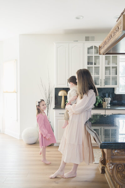 A pregnant mother holds a bouquet of flowers near her bump.