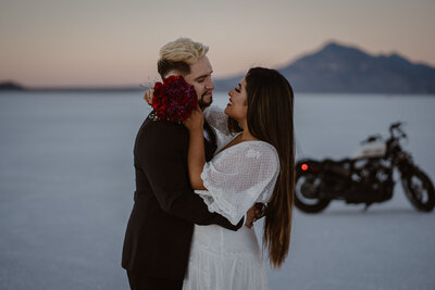 Couple elopes on the Bonneville Salt Flats in Utah with their motorcycle.