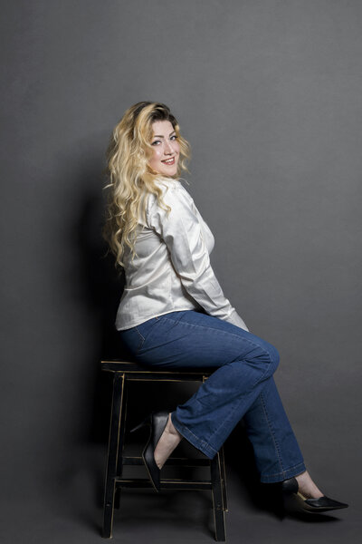 blonde woman sitting on stool