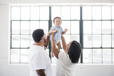 indoor-industrial-baby-family-photoshoot-holding-baby-up