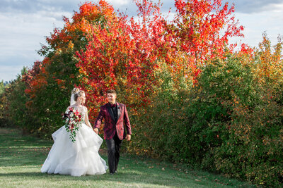 Newlywed couple walking with fall trees
