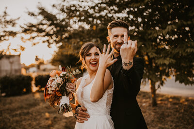 bride and groom showing off their rings